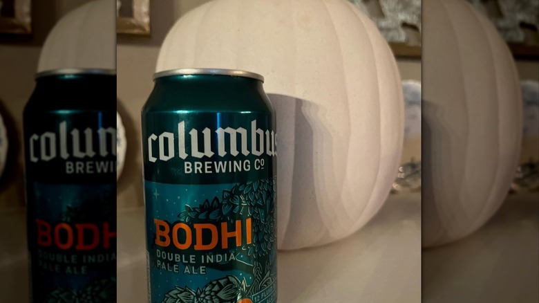 A can of Bodhi in front of a white pumpkin.