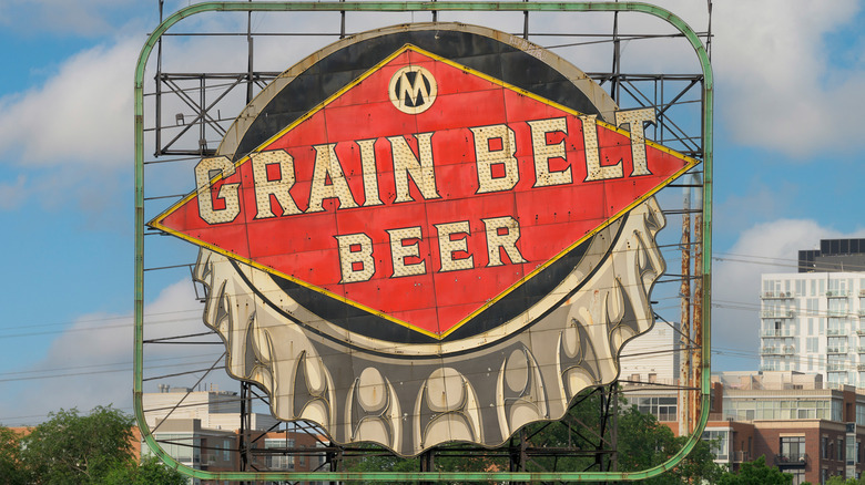Grain Belt Beer road sign with city buildings in the background