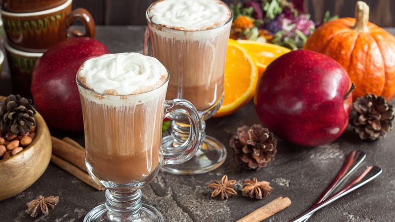 A warm apple cider drink with whipped cream
