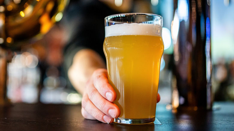 Bartender sliding beer across bar