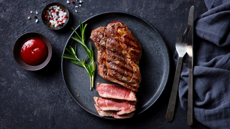 Cut medium rare steak and salt