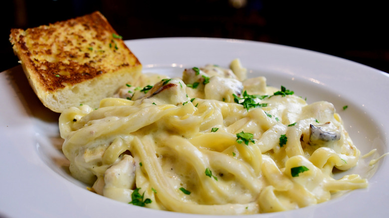 pasta in alfredo sauce with a side of garlic bread