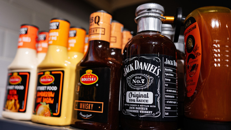 Bottles of BBQ sauce on store shelf including Jack Daniels brand