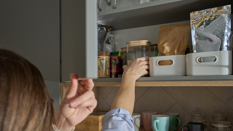 person reaching into pantry