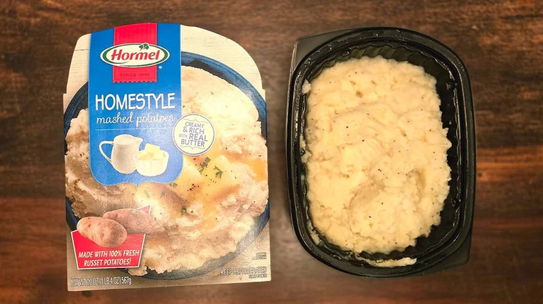 Hormel mashed potatoes packaging and container on a dark wood surface