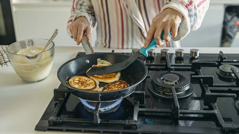 Person using spatula to cook pancakes