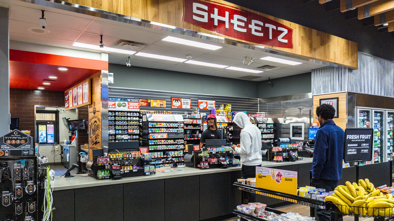 A Sheetz checkout counter with customers bing served.