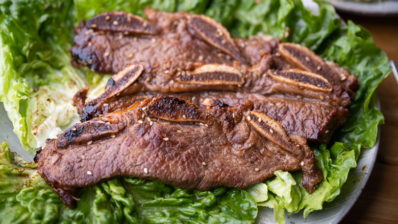 Grilled flanken short ribs on a bed of lettuce