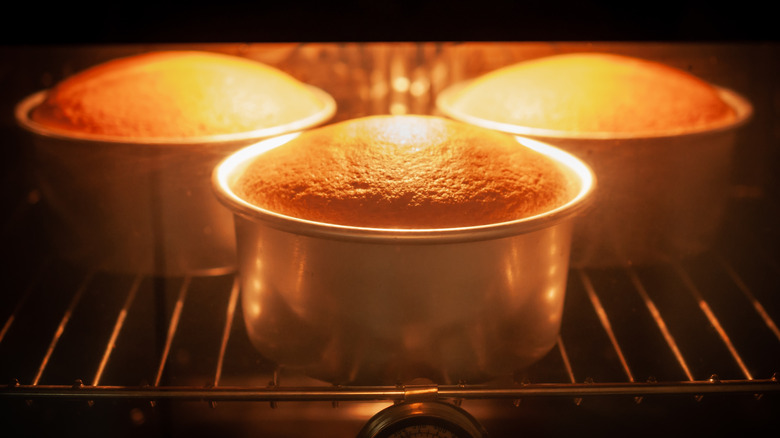 Trio of cakes rising in oven