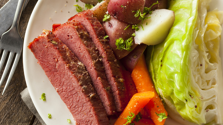 A plate of corned beef with carrots and potatoes