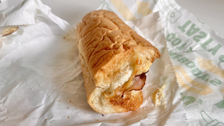 A half-eaten Subway breakfast sandwich