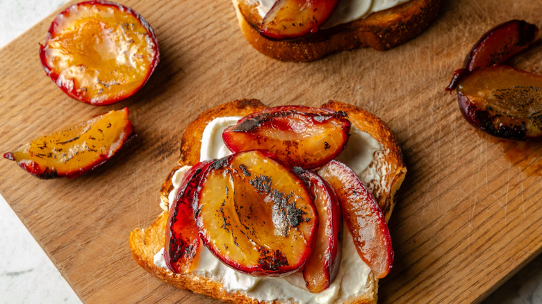 grilled plums on toaste with herbs and cream cheese