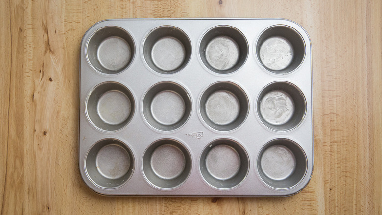greased muffin tin on table