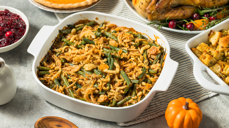 Green bean casserole with fried onions in white casserole dish