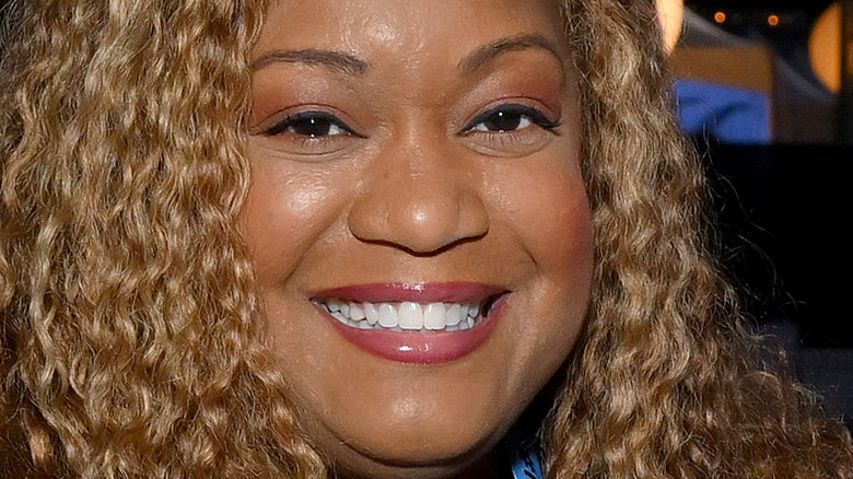 Sunny Anderson smiles with lipstick