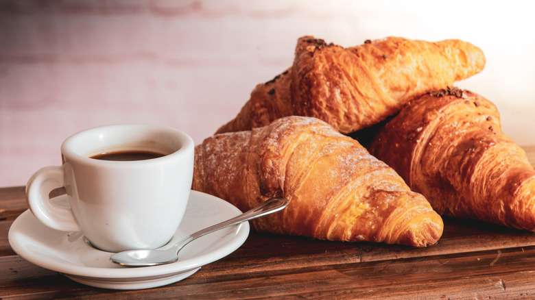 An espresso next to three Italian cornetti