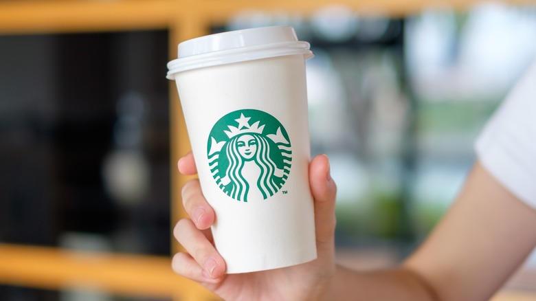 Hand holds Starbucks cup