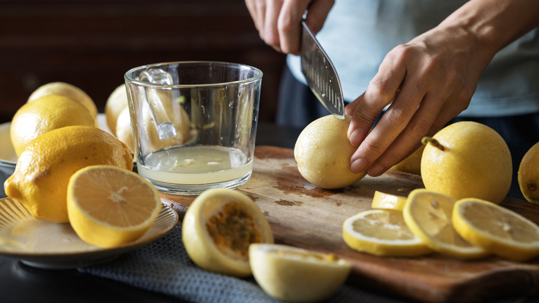 Person chopping up lemons for lemonade in a kitchen