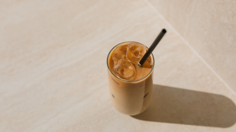 An iced latte in a glass with a straw