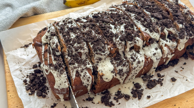 Banana bread topped with glaze and crushed Oreos