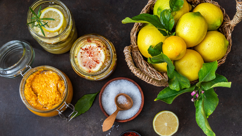 Fresh lemons and jars of preserved lemons