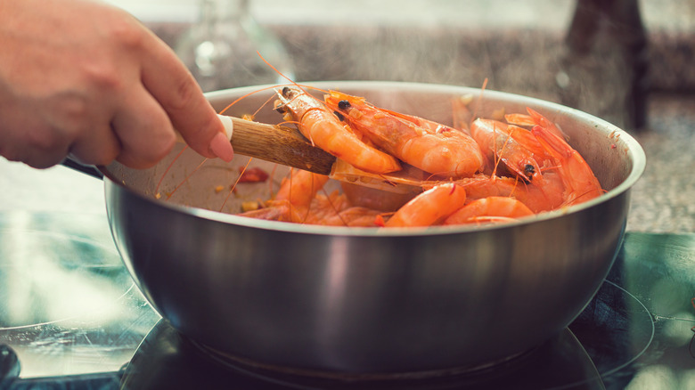 Man cooking shrimp in pot