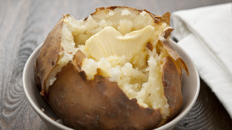 Opened baked potato with butter