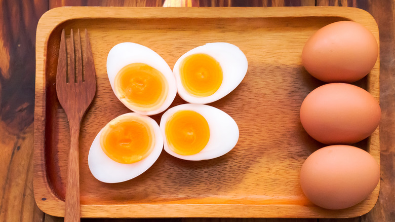 Cooked eggs on wooden plate