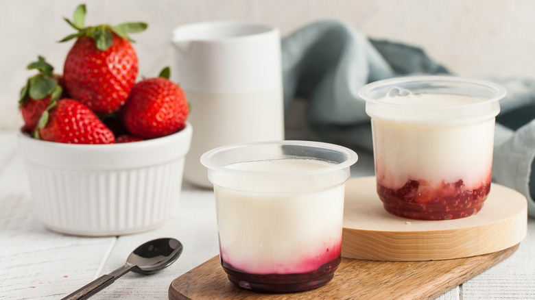 Strawberries in bowl with milk fruit beverages and spoon