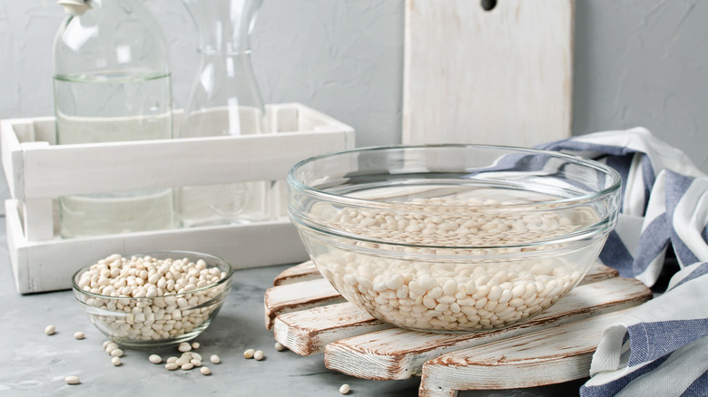 White beans soaking in glass bowl