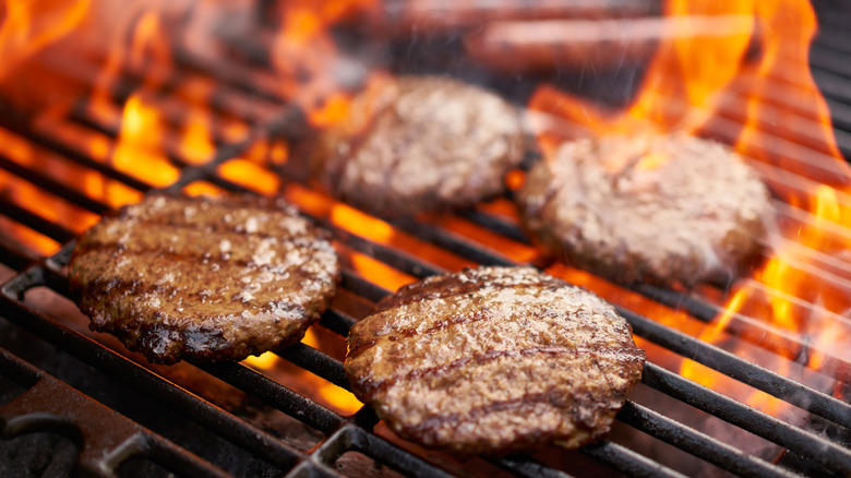 thin burgers on a fiery grill