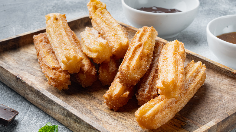 Stack of churros on wooden tray
