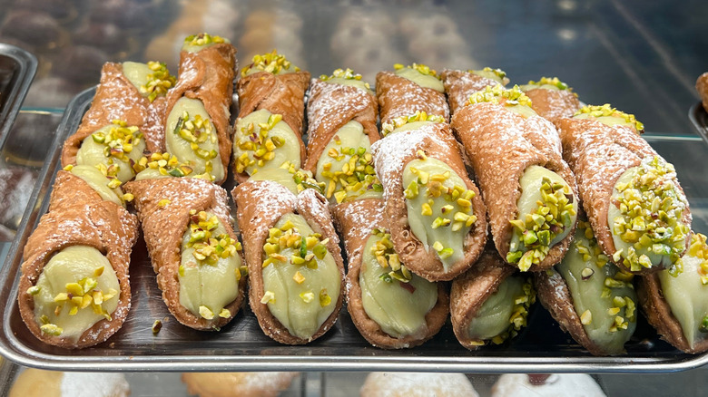 stack of pistachio cannoli in bakery window