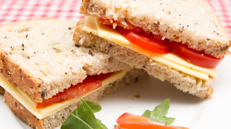 A cheese and tomato sandwich on a plate.