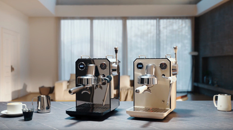 Two Gemilai Owl G3006 machines on a counter next to milk jugs and coffee cups