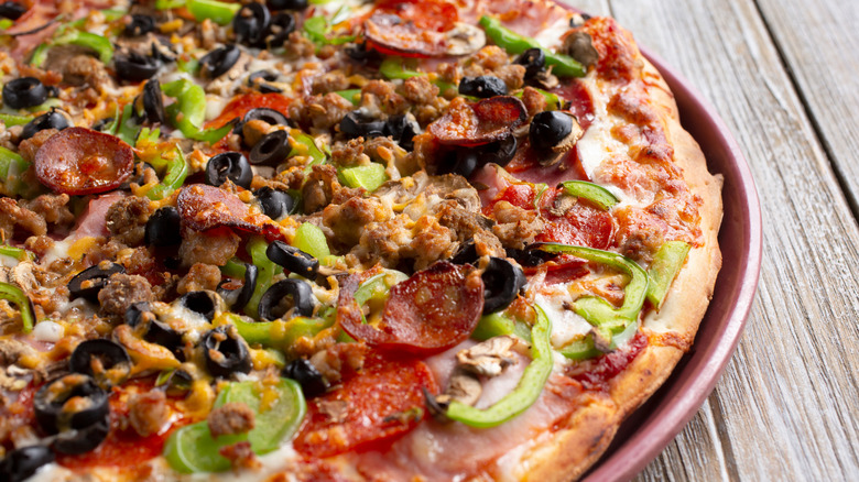 Loaded supreme pizza on pan