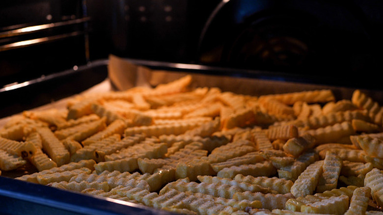 Tray of frozen fries baking in an oven