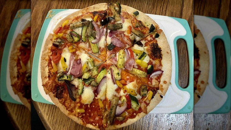 Baked frozen pizza topped with roasted vegetables.