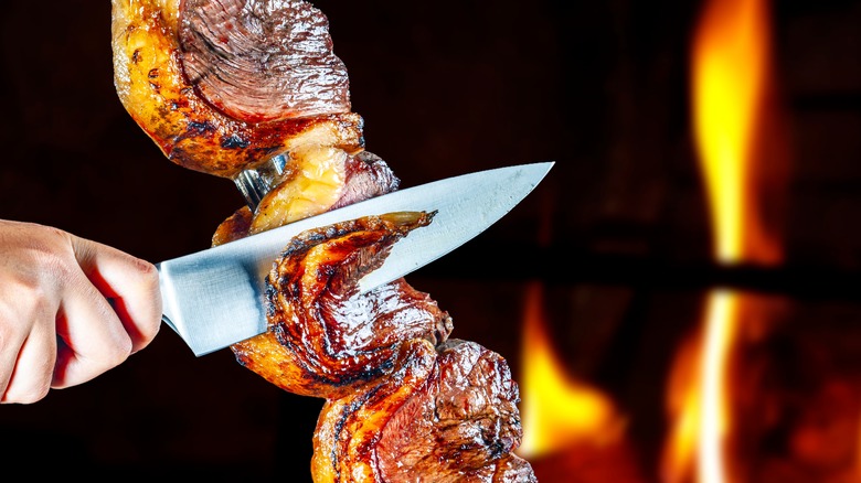 slicing meat at brazilian steakhouse 