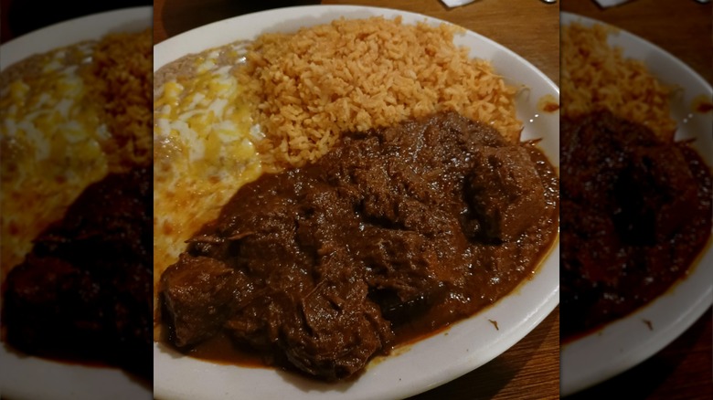 A plate of chile Colorado with beans and rice