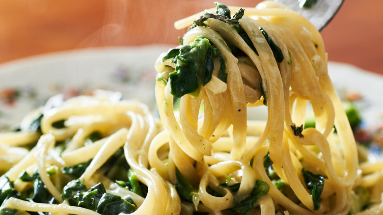 Forkful of linguine pasta with spinach 