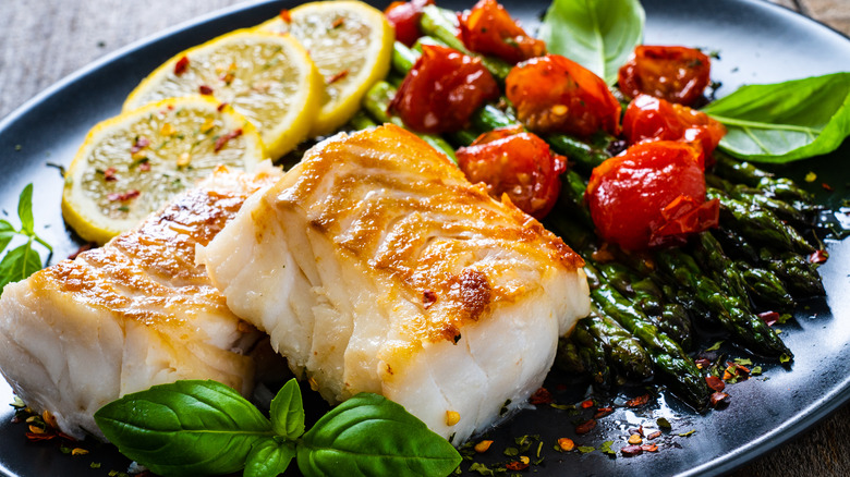 Fried cod fillet with tomatoes and asparagus