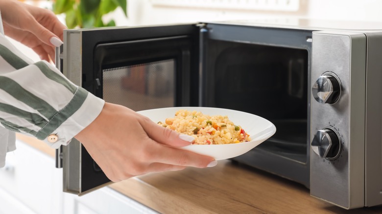 personing taking food from microwave