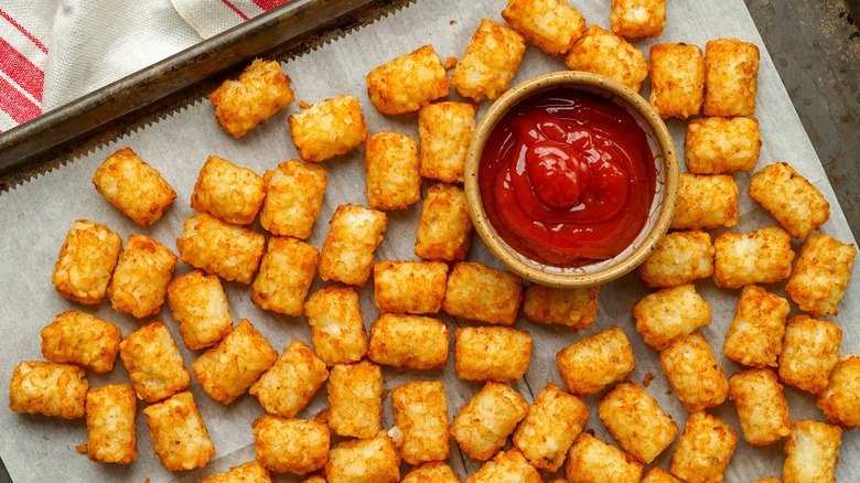 tater tots with ketchup on a baking sheet
