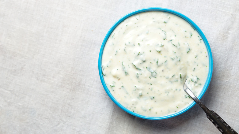 Ranch dressing in small blue bowl with spoon.