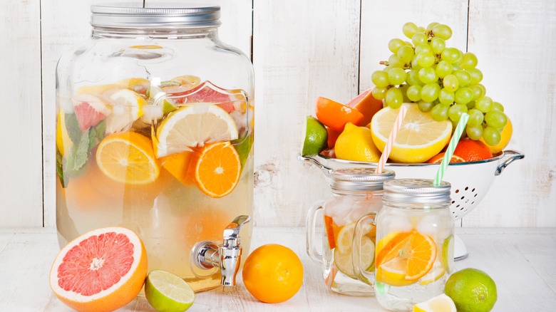 Fruit infused water in drink dispenser with glasses