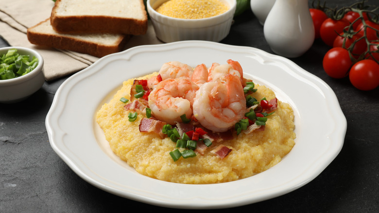 Bowl of grits topped with shrimp, bacon, and green onion