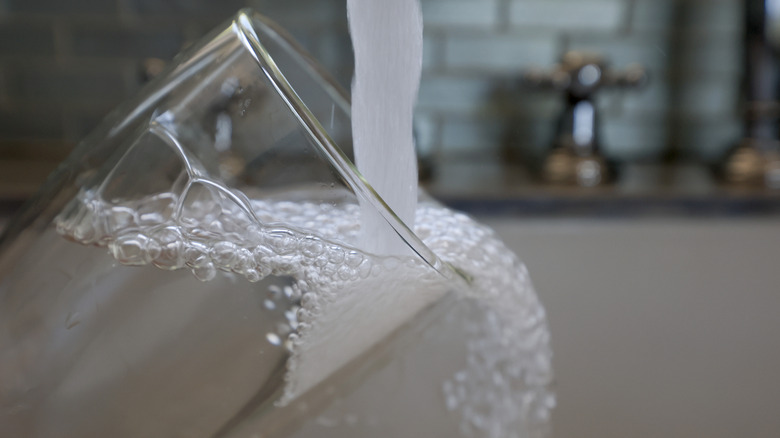 Tap water runs into container