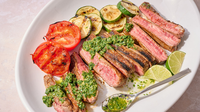 steak and chimichurri on a platter