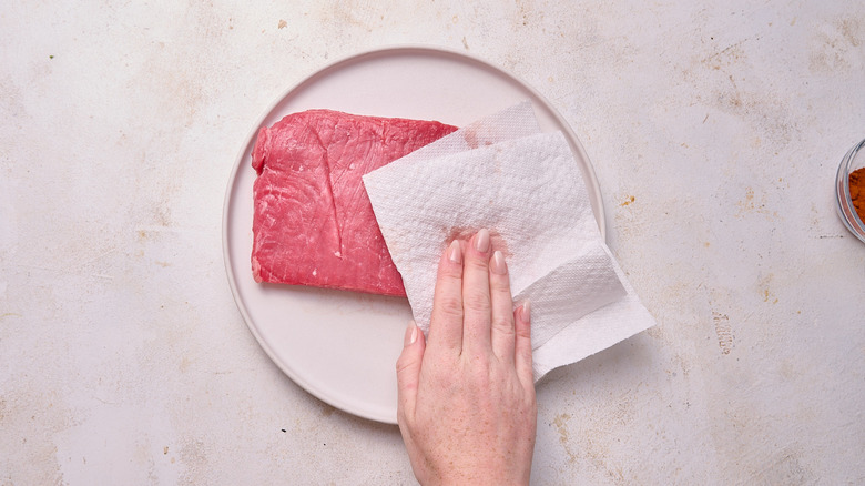 patting steak dry with paper towel